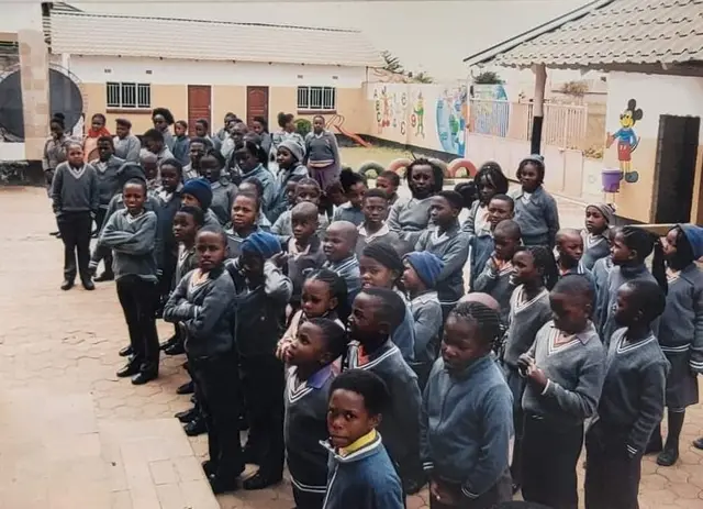 Quick Step pupils in grey uniform lined up in the school grounds